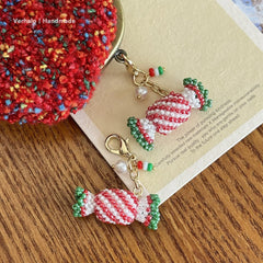 Handmade beaded candy charm on a wooden surface with 'Verheze Handmade' label.