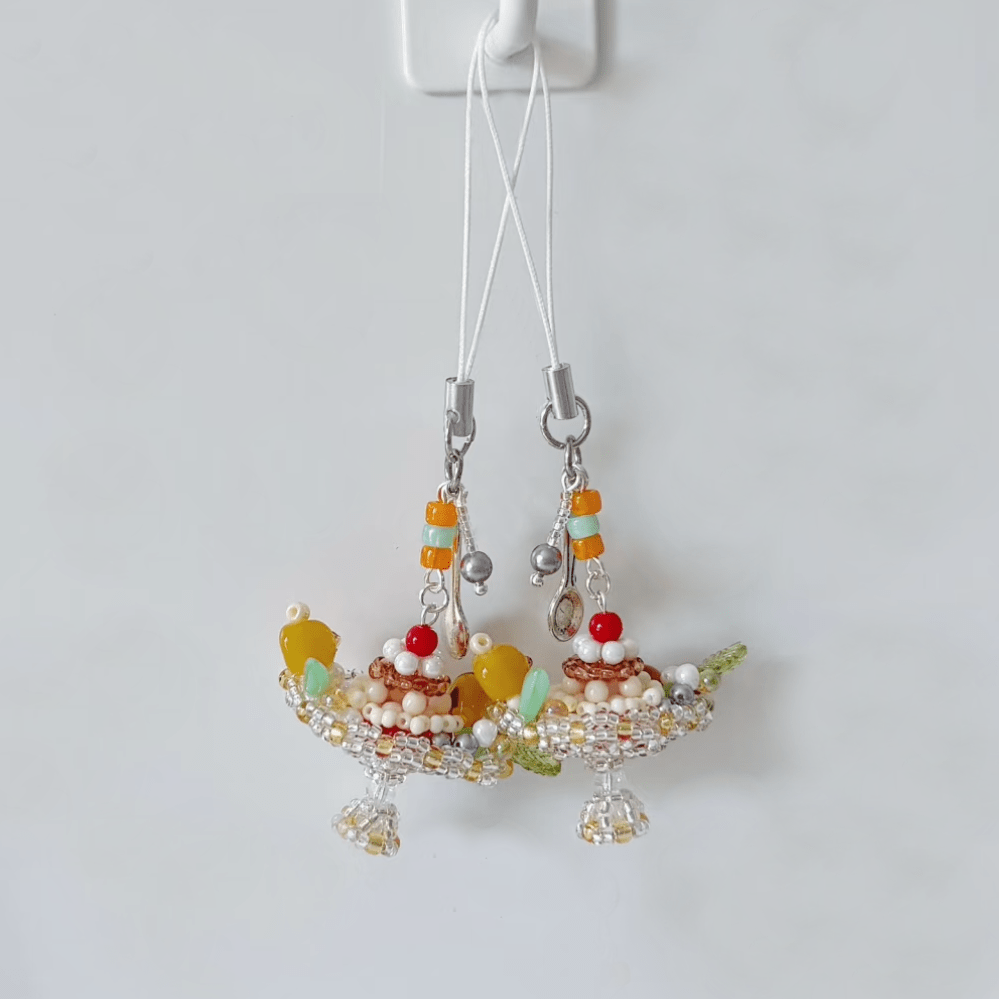 Beaded pudding boat phone charm with colorful beads on a white background