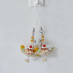 Beaded pudding boat phone charm with colorful beads on a white background
