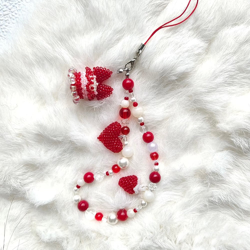 Beaded cake phne strap with red and white beads on a white fur background