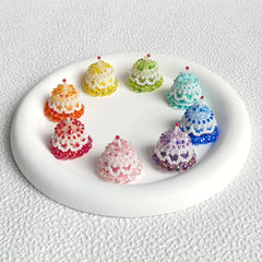 Colorful beaded cake decorations on a white plate