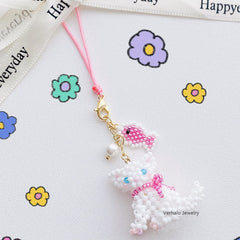 Beaded white cat charm with pink accents on a white background with colorful flowers丨Verhal Custom Jewelry