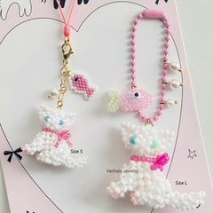 Two white cat charms with pink bows on a pink heart-shaped background丨Verhal Custom Jewelry