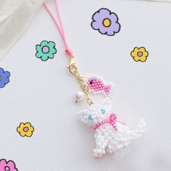 Beaded charm shaped like a cat with a pink bow on a white background with colorful flowers.