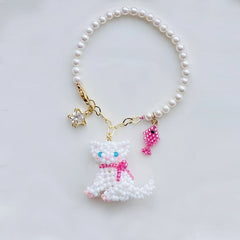 Pearl bag charm with a cat charm on a light gray background