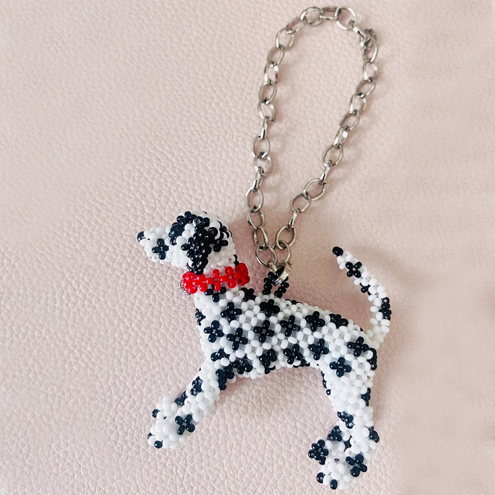 Beaded Dalmatian dog bag charm with a red collar on a pink background- verhalo jewelry
