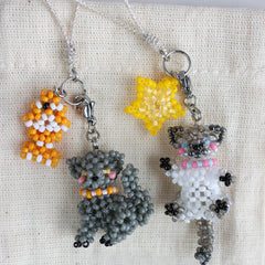 Two beaded cat charms, one with a fish and the other with a star, on a white background. - verhalo custom jewelry