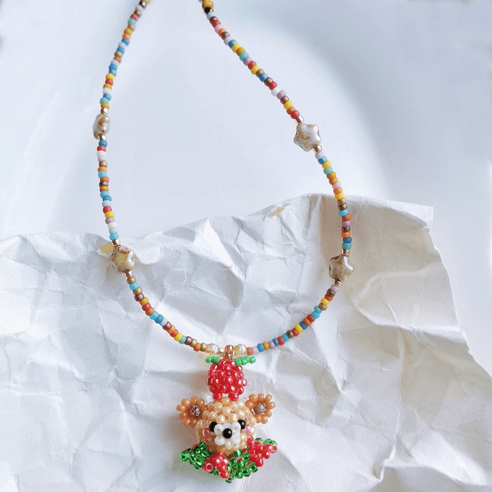 Colorful beaded necklace with a christmas bear pendant on a white background