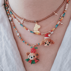 Colorful beaded necklaces with cartoon character pendants on a person's chest.