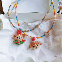 Colorful beaded necklace with a dog-shaped pendant on a white fabric background