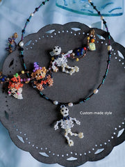 Necklace with skeleton charms on a decorative black plate