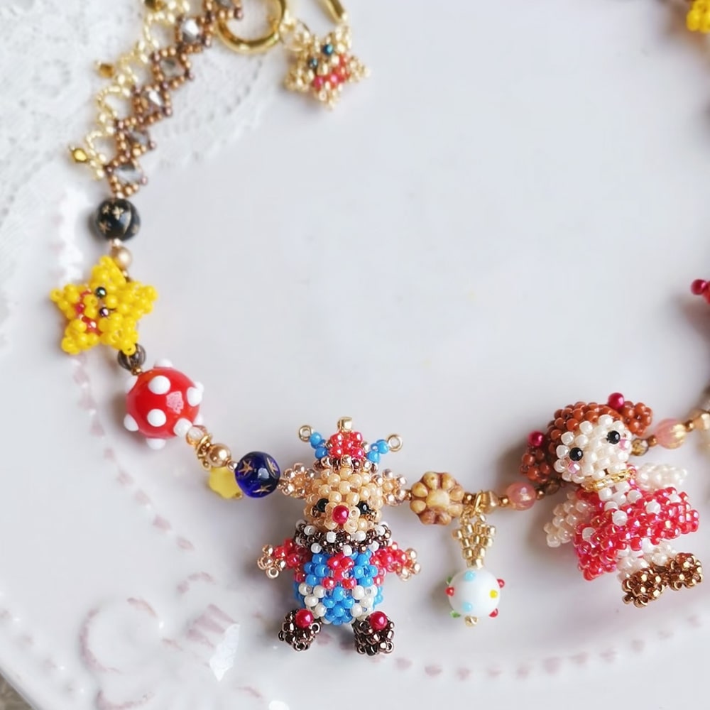 Colorful beaded birthday party necklace with character charms on a white background