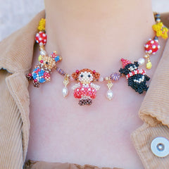 Colorful beaded birthday party  necklace with decorative elements on a person wearing a beige jacket.