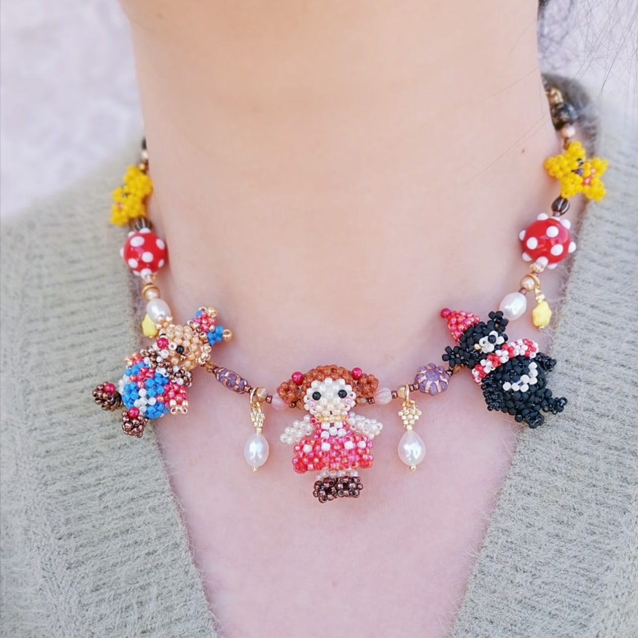 Colorful beaded birthday party necklace with character pendant on a neutral background