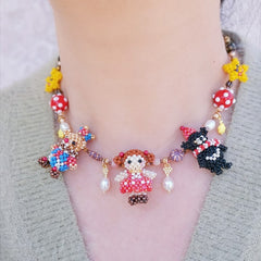 Colorful beaded birthday party necklace with character pendant on a neutral background