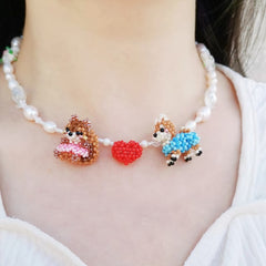 Necklace with Shiba Inu dog, squirrel and heart designs on a plain background