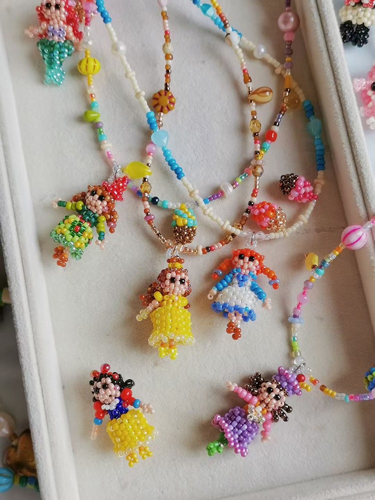 Colorful beaded necklaces with princess figures on a white surface