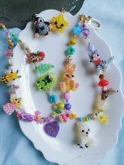 Colorful beaded keychains on a white plate with a blue background