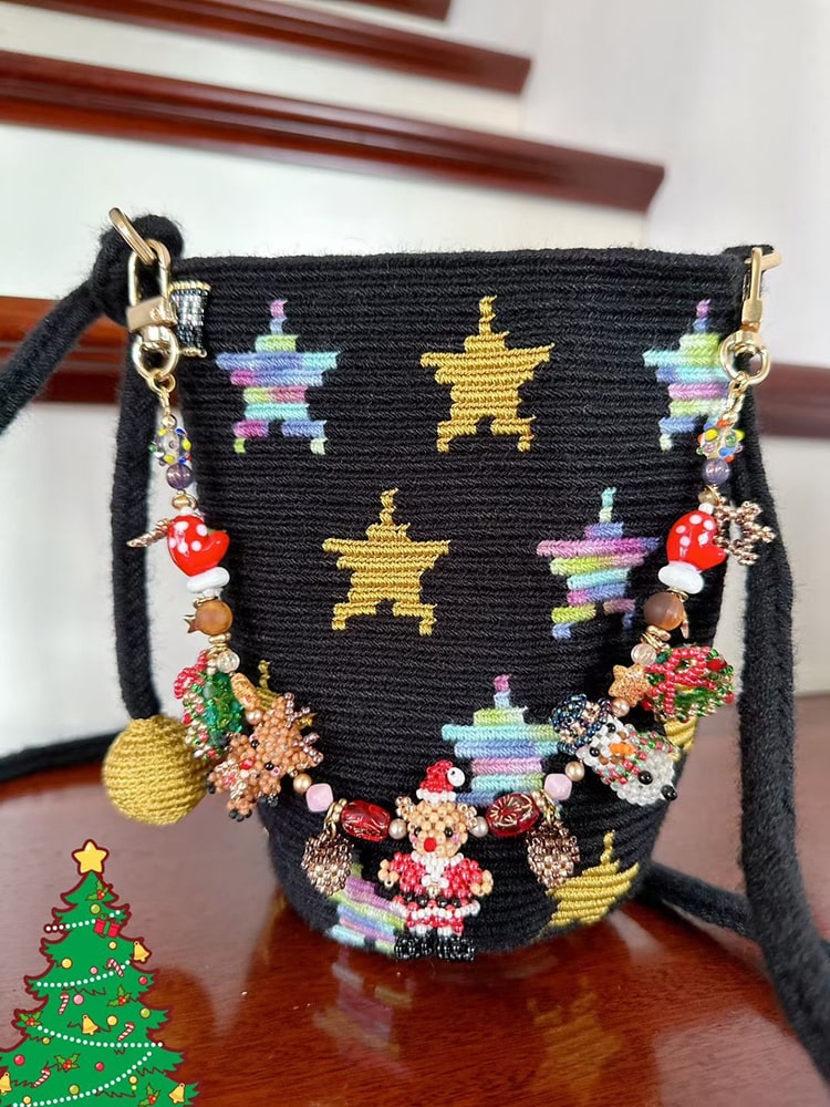 Black handbag with colorful star patterns and charms on a wooden surface.- verhalo custom jewelry