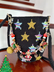 Black handbag with colorful star patterns and charms on a wooden surface.- verhalo custom jewelry