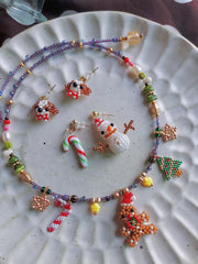 Colorful beaded necklace and earrings on a textured white plate- verhalo custom jewelry