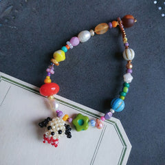 Colorful beaded bracelet with a dog charm on a dark surface - verhalo handmade jewelry