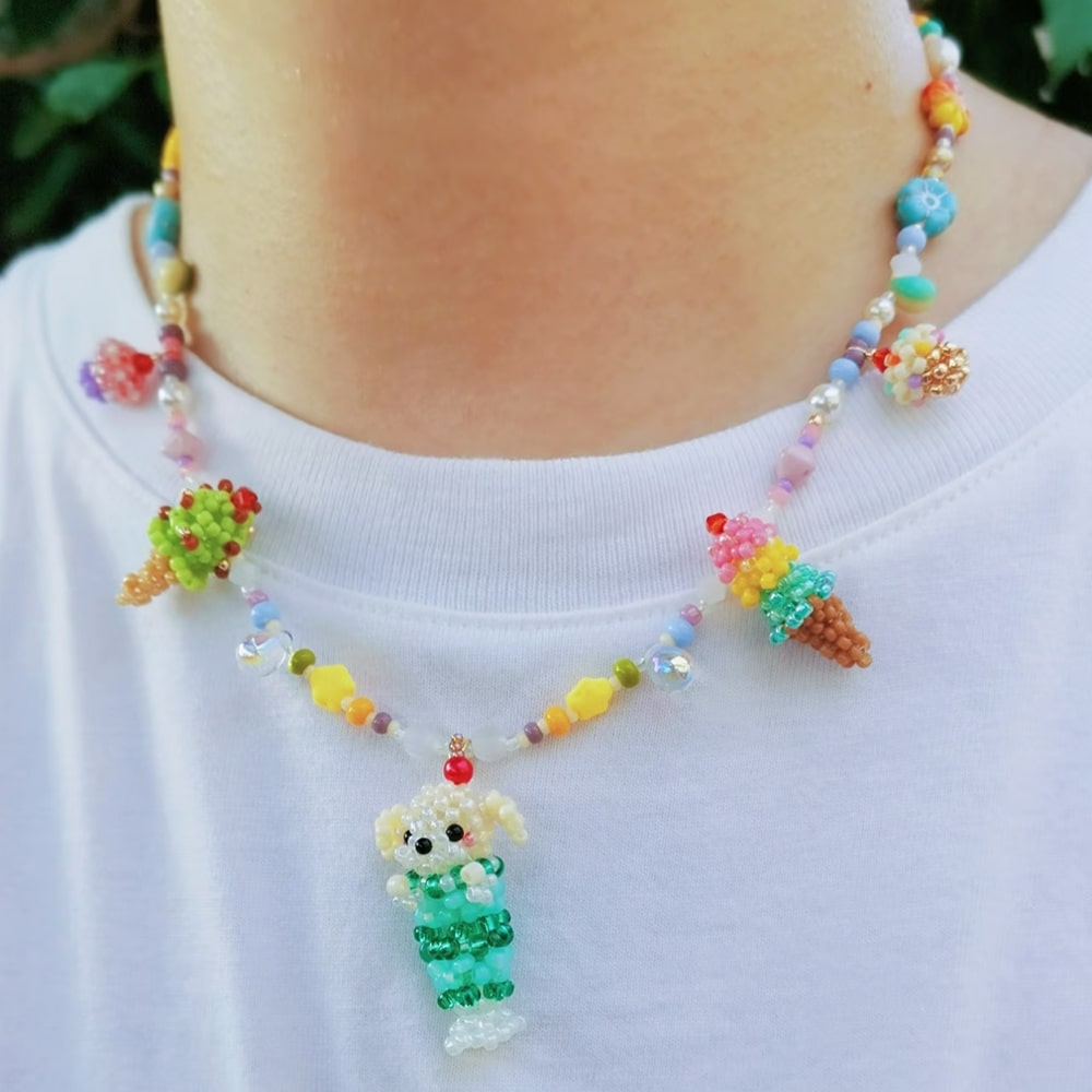 Colorful beaded necklace with ice creams and dog pendant on a white shirt.