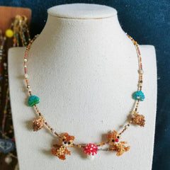 Necklace with squirrel and flower designs on a mannequin bust against a blue background  - verhalo custom jewelry