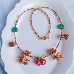 Necklace with two squirrels and apple charms on a white plate - verhalo custom jewelry