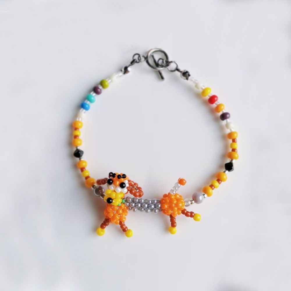 Colorful beaded bracelet with a dog-shaped charm on a white background