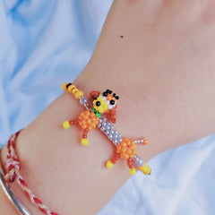 Colorful beaded dog bracelet on a wrist with a light blue background