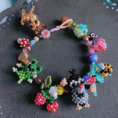 Colorful beaded bracelet with animal and nature-themed beads on a dark surface - Verhalo Custom Jewelry