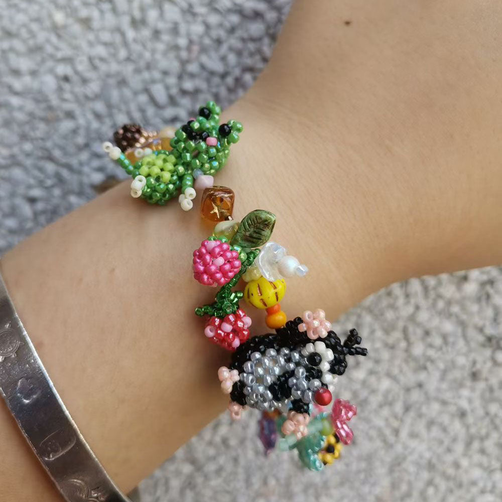 Colorful beaded garden bracelet on a wrist with a textured background  - Verhalo Custom Jewelry
