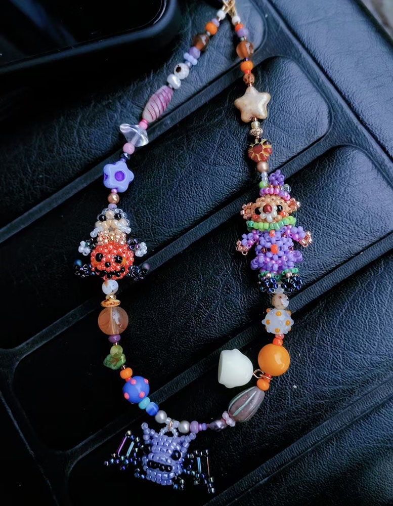 Colorful beaded Halloween bag charm on a dark textured surface - Verhalo custom jewelry