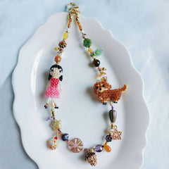 Colorful beaded bag charm with a little girl and her dachshund dog on a white plate - Verhalo custom jewelry