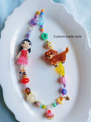 Colorful beaded bag charm with a girl and dachshund dog charms on a white plate. - Verhalo custom jewelry