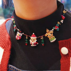 Necklace with festive charms including a Santa Claus figure and Christmas trees, worn by a person. - verhalo custom jewelry