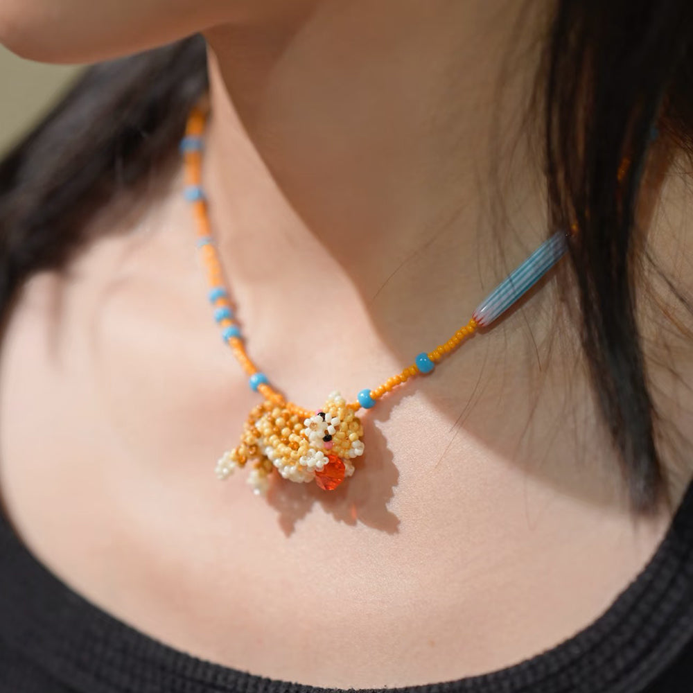 Necklace with a colorful cat pendant worn by a person