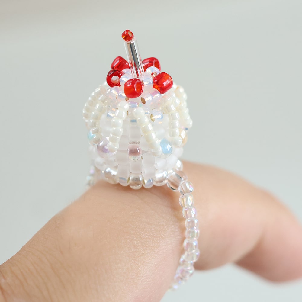 Beaded cake ring with red beads on a light background