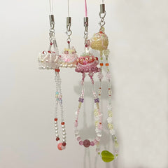 Decorative string with colorful beads and cake charms on a white background