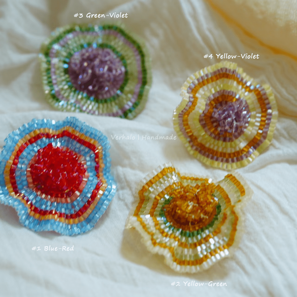 Four colorful beaded flower designs on a textured white background