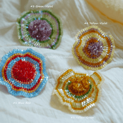 Four colorful beaded flower designs on a textured white background