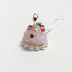 Decorative cake charm with beads and pearls on a white background