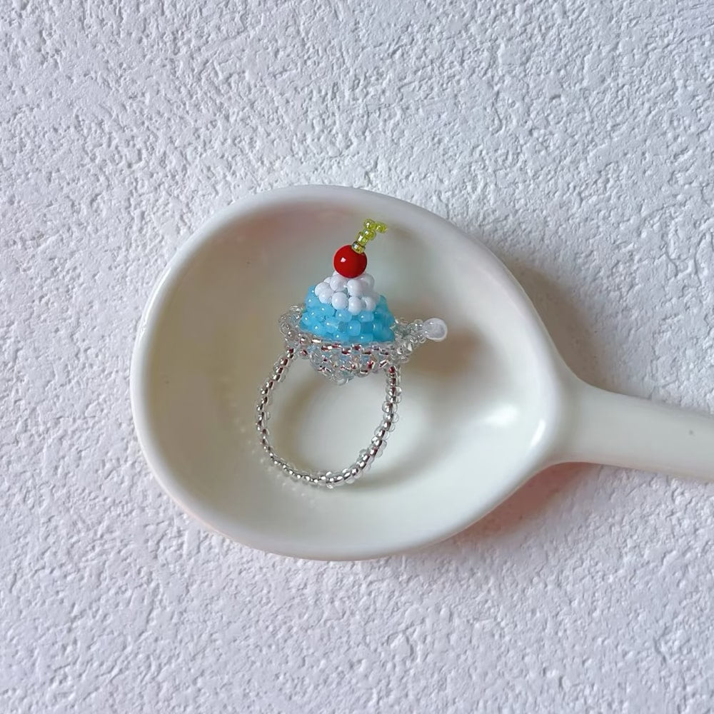 Small decorative ring shaped like a ice pudding on a white spoon against a white background