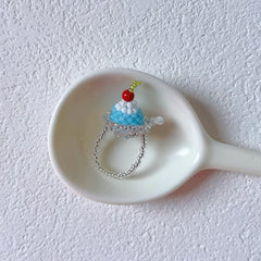Small decorative ring shaped like a ice pudding on a white spoon against a white background