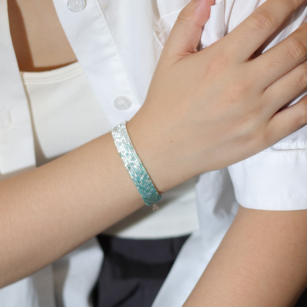Person wearing a tbeadedbracelet on a plain background