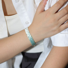 Person wearing a tbeadedbracelet on a plain background