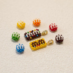 Colorful beaded jewelry pieces on a textured beige surface