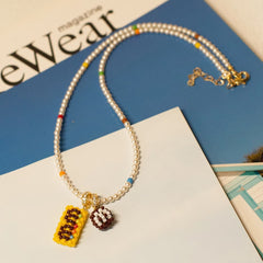 Pearl necklace with colorful charms on a magazine background