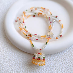 Beaded cake necklace with colorful beads on a white surface
